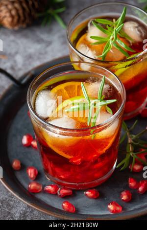 Cocktail di melograno decorato con lime, rosmarino e ghiaccio, bevanda fredda Foto Stock