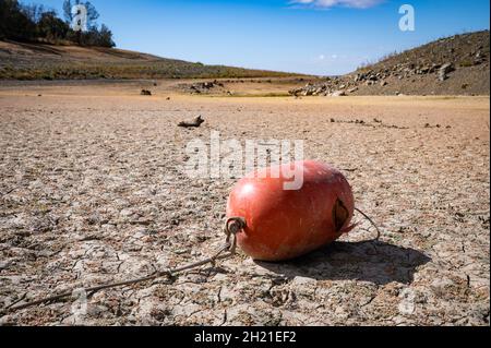 Una boa d'arancio adagiata su una zona marina vuota del lago Folsom. I livelli dell'acqua sono ai minimi storici a causa della mancanza di pioggia, del tempo caldo e dei rilasci d'acqua. Foto Stock