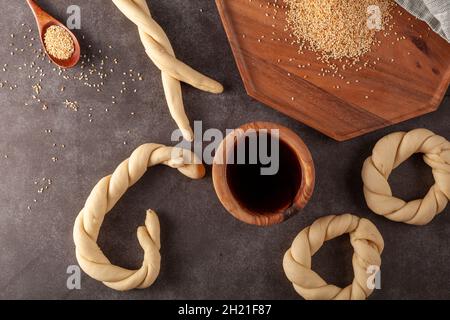 Immagine dall'alto che mostra la preparazione di un delizioso bagel turco con semi di sesamo noti come susamli simit. Una volta che i cerchi di stile di cruller intrecciati sono fatti il Foto Stock