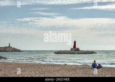 Faro rosso all'ingresso del porto di Villajoyosa in una giornata nuvolosa e soleggiata in provincia di Alicante, Spagna, Europa Foto Stock