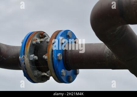 Sistema di tubi in acciaio o rame per impianto di raffreddamento HVAC a freddo con flange all'aperto che mostrano ruggine e nastri di acciaio Foto Stock