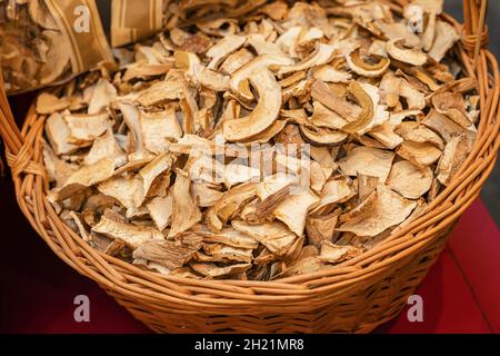 Fette di funghi secchi in cestino di vimini, raccolta della foresta autunnale Foto Stock
