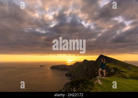 Donna caucasica che guarda la vista delle scogliere di Croaghaun, Achill Island, Irlanda Foto Stock