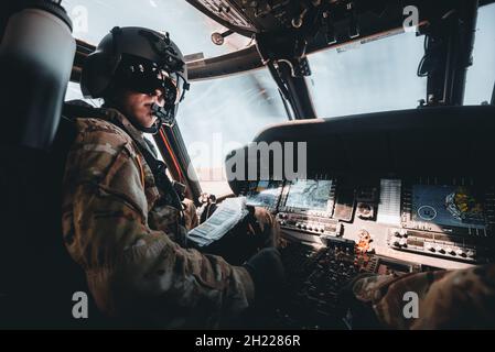 Un pilota in elicottero UH-60 Black Hawk, assegnato alla 25a Brigata dell'Aviazione da combattimento, guarda verso il suo co-pilota durante le operazioni di volo a Kauai, Hawaii, 13 ottobre 2021. La 25a Brigata dell'Aviazione di combattimento fornisce supporto multifunzionale all'Aviazione della 25a Divisione di Fanteria per condurre azioni decisive a sostegno delle operazioni terrestri unificate. (STATI UNITI Foto dell'esercito dello staff Sgt. Timothy Hamlin) Foto Stock