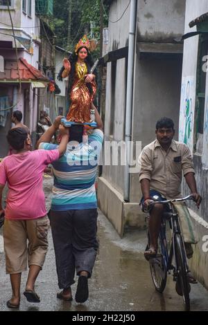 Howrah, India. 19 Ott 2021. I devoti sono visti portare l'idolo di laxmi. Kojagari Puja, noto anche come Bengala Laxmi Puja. Kojagari Puja si svolge in una giornata di luna piena nel mese di Ashwin del calendario indù. Viene eseguito in onore della Dea Lakshmi. Quest'anno, Kojagari Puja sarà celebrato il 19 ottobre Credit: SOPA Images Limited/Alamy Live News Foto Stock