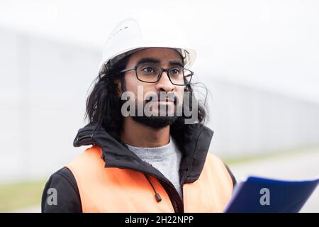 Tecnico con barba e casco lavora in un'officina, Friburgo, Baden-Wuerttemberg, Germania Foto Stock