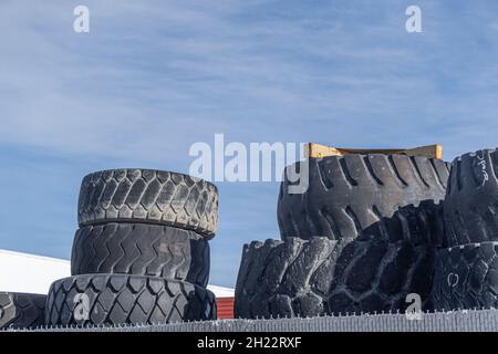 Vecchi pneumatici impilati insieme in un garage di officina Foto Stock