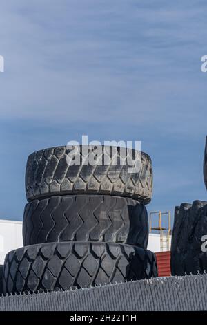 Vecchi pneumatici impilati insieme in un garage di officina Foto Stock