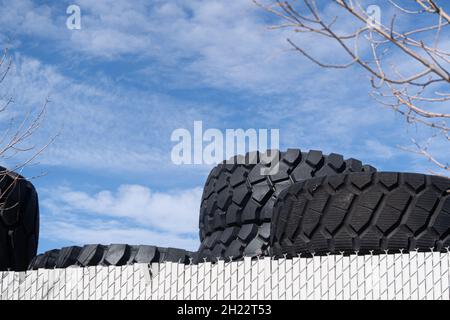 Vecchi pneumatici impilati insieme in un garage di officina Foto Stock