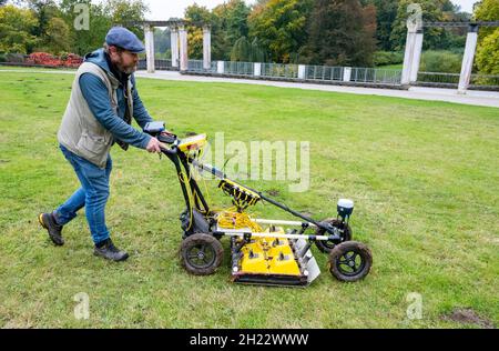 Putbus, Germania. 19 Ott 2021. Immo Trinks dell'Università di Vienna lavora nel parco del castello con un cosiddetto radar a penetrazione di terra. Il dispositivo è stato utilizzato per esplorare il sito dove un tempo sorgeva il castello. Insieme alle fotografie, sul computer deve essere creato un modello di strutture sopra e sotto terra. L'azione fa parte del centro maniero dell'Università di Greifswald, dal quale si ricercano fino a 15,000 manieri e castelli della regione baltica. (A dpa 'High-tech rasaerba esamina resti di Putbus Castello') credito: Stefan Saae/dpa/Alamy Live News Foto Stock