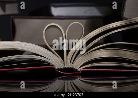 Primo piano delle pagine del libro piegate a forma di un cuore Foto Stock