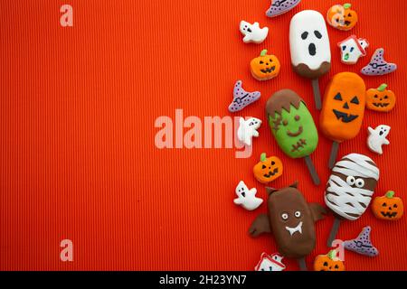 Set di gelato e biscotti con il volto di Halloween su sfondo arancione. Halloween partito sfondo Foto Stock