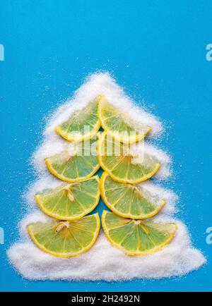 Albero di Natale a base di limone e zucchero su sfondo blu. Foto Stock