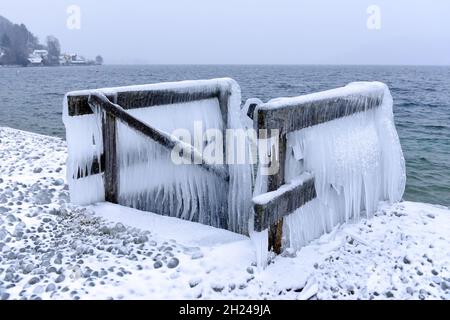 Das Vom Wind ans Ufer gepeitschte Wasser ließ Bänke, Einstiege und Geländer am Ufer des Attersees vereisen. - l'acqua schiacciata dal vento ha fatto le banche, Foto Stock