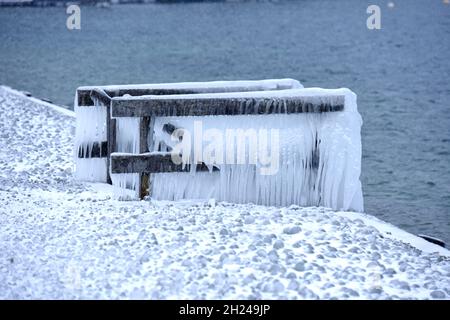 Das Vom Wind ans Ufer gepeitschte Wasser ließ Bänke, Einstiege und Geländer am Ufer des Attersees vereisen. - l'acqua schiacciata dal vento ha fatto le banche, Foto Stock