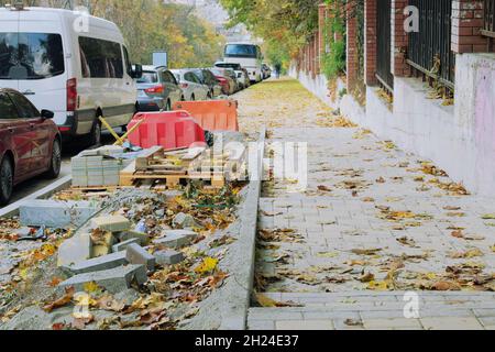 Pavimentazione in pietra per la riparazione dei sentieri. Riparazione del marciapiede della città in autunno. Foto Stock