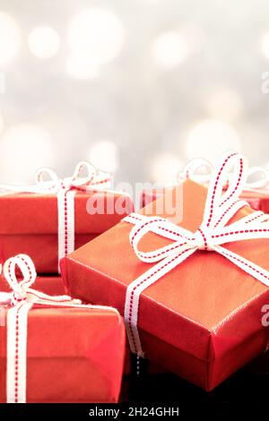 Foto ravvicinata di confezioni regalo rosse e bokeh circolari. Amore, dono e concetto del presente. Foto Stock