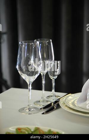 L'impostazione del tavolo nel ristorante. I vini serviti per una cena festiva. Ambiente tavolo in un ristorante moderno. Tavolo da festa decorato. Foto Stock