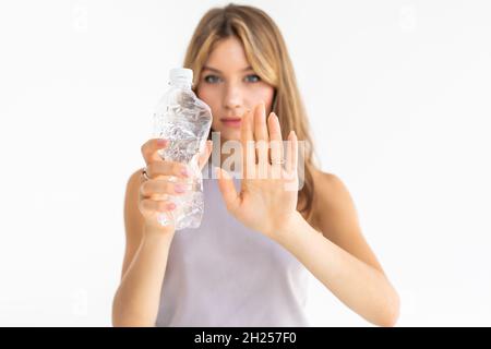 Giovane bella donna riciclaggio bottiglie di plastica in piedi su sfondo bianco isolato con mano aperta facendo segno di stop con grave e sicuro expr Foto Stock