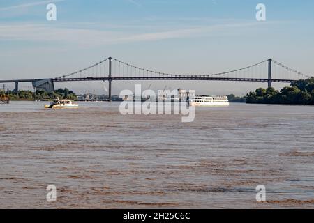 Una nave da crociera che piange il fiume Garonna di fronte al Pont d'Aquitania a Bordeaux, un importante porto da crociera nel sud della Francia Foto Stock