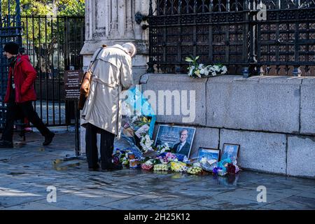 WESTMINSTER LONDRA, REGNO UNITO. 20 Ott 2021. Un passer by vede i tributi floreali e i messaggi di simpatia posti da ben wishers a Sir David Amess deputato conservatore per Southend West che è stato assassinato alla sua chirurgia di circoscrizione a Leigh-on-Sea Essex il 15 ottobre dalla suppl in custodia chiamata Ali Harbi Ali. Credit: amer Ghazzal/Alamy Live News Foto Stock