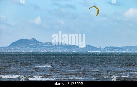 Bent Longniddry. East Lothian, Scozia, Regno Unito, 20 ottobre 2021. UK Meteo: Giornata ventosa per i kite surfisti. I kitesurfers godono il clima blustery in una giornata di sole nel Firth of Forth con una vista di Edinburgo e Arthur's Seat in lontananza attraverso la baia Foto Stock