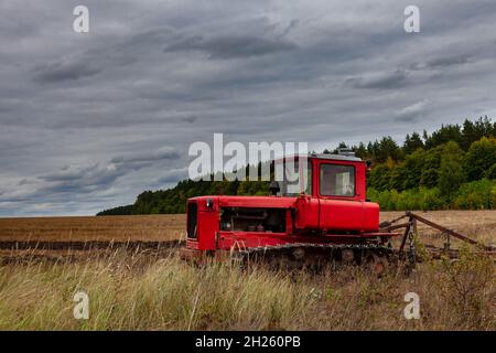 trattore cingolato in posizione eretta in un campo su terreni arabili. Foto di alta qualità Foto Stock