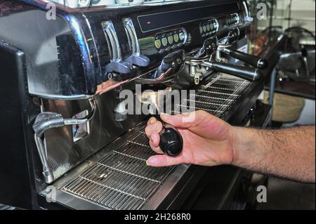 Il cameriere fa un buon caffè nella macchina espresso Foto Stock