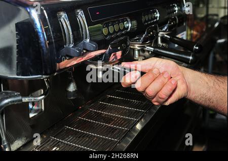 Il cameriere fa un buon caffè nella macchina espresso Foto Stock