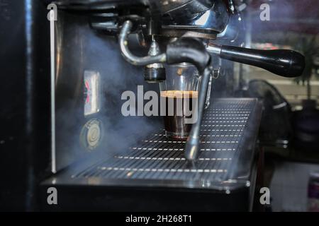 Il cameriere fa un buon caffè nella macchina espresso Foto Stock