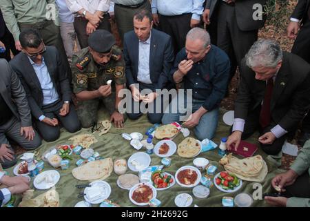 Cisgiordania, Nablus, Palestina. 20 Ott 2021. Il primo ministro palestinese Muhammad Shtayyeh mangia la colazione nei campi di olivo durante la stagione della raccolta delle olive nella città di Salfit, in Cisgiordania. Credit: Nasser Ishtayeh/ZUMA Wire/Alamy Live News Foto Stock