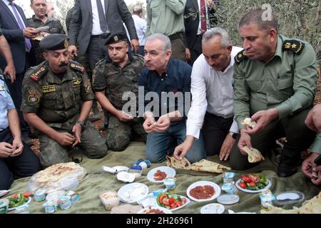 Cisgiordania, Nablus, Palestina. 20 Ott 2021. Il primo ministro palestinese Muhammad Shtayyeh mangia la colazione nei campi di olivo durante la stagione della raccolta delle olive nella città di Salfit, in Cisgiordania. Credit: Nasser Ishtayeh/ZUMA Wire/Alamy Live News Foto Stock