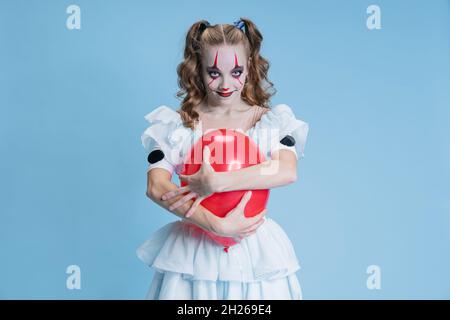 Ritratto concettuale di affascinante giovane ragazza in costume di Halloween di personaggio del film con l'espressione del viso spoky isolato su sfondo blu Foto Stock