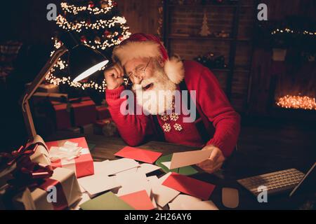 Foto ritratto babbo natale con barba bianca indossando occhiali da lettura wishlist prima di Natale ridere overjoyed Foto Stock