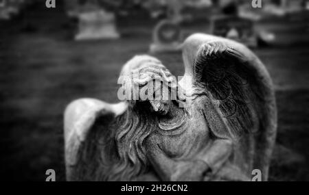 Lapide lapide lapide in statua di angelo cimitero dolore e ricordo ali e preghiera Foto Stock