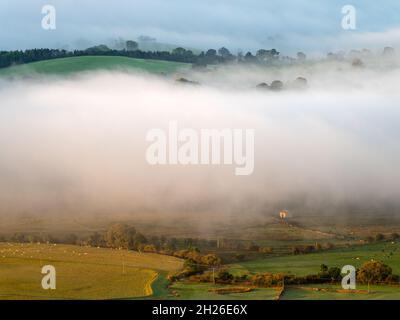 La nuvola bassa si aggira sul paesaggio dello Yorkshire del distretto di Craven in una mattinata d'autunno frizzante mentre la prima luce diretta cattura la scena rurale. Foto Stock