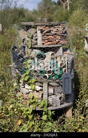 Il grande insetto o bug hotel è un rifugio artificiale con diverse sezioni per fornire nesting o facoltà di rifugio per molti tipi di insetti Wildfowl e. Foto Stock