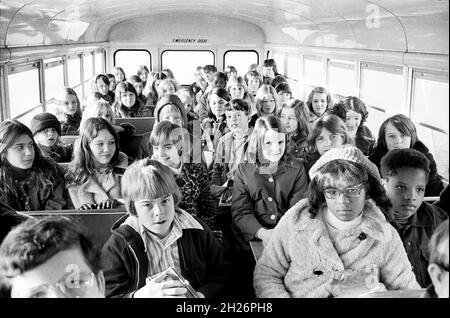 Bambini della scuola del bianco e del nero su bus della scuola, cavalcando dai Suburbs ad una scuola interna-città, Charlotte, Carolina del Nord, Warren K. Leffler, collezione della rivista di notizie & di rapporto di mondo di Stati Uniti, 1973 Foto Stock