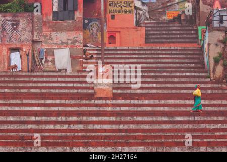 Varanasi, India – 3 marzo 2015: Donna non identificata che si fa strada poco dopo l'alba lungo i passi di Narad ghat sopra una zona di balneazione indù Foto Stock