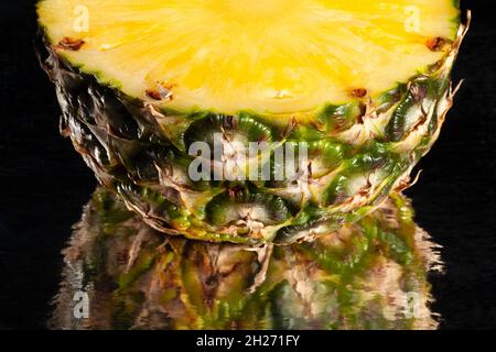 ananas a fette specchiato su sfondo nero Foto Stock