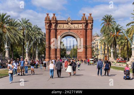 Arc de Triomf - i turisti si godono un soleggiato pomeriggio d'autunno sull'ampio lungomare di Passeig de Lluís Companys all'Arc de Triomf di Barcellona, Spagna. Foto Stock