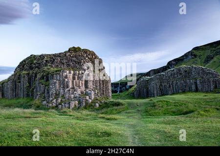 Affioramenti basaltici colonnari (e cascata sullo sfondo), Dverghamrar (scogliere nane), vicino a Foss, Islanda Foto Stock