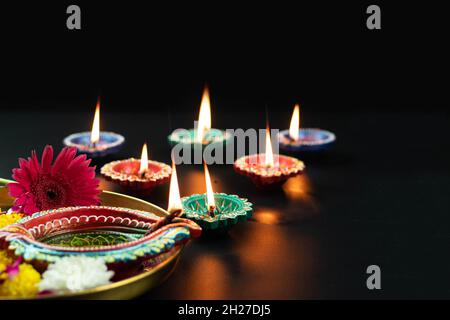 Varie dimensioni Clay Diya fatto a mano, profondo o dia illuminato in scuro e Golden Thali decorato con fiori di lana. Tema per Diwali Pooja, Navratri, Duss Foto Stock