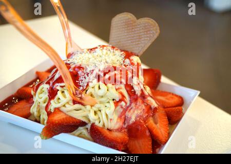 gelato agli spaghetti con salsa di fragole e fragole grandi Foto Stock