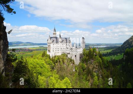 Castello bavarese Neuschwanstein e lago Forggensee in background fotografato dal ponte Marienbruecke Foto Stock