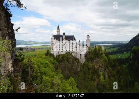 Castello bavarese Neuschwanstein e lago Forggensee in background fotografato dal ponte Marienbruecke Foto Stock