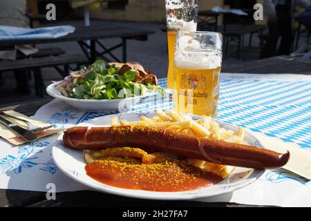 Delizioso currywurst tedesco fritto caldo con patatine fritte e salsa al curry e birra chiara del re Ludwig nella birreria all'aperto, Schwangau, Baviera, Germania Foto Stock