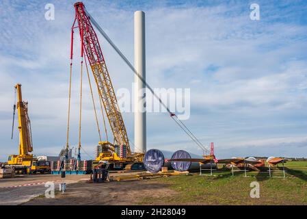 Cantiere preparato per l'assemblaggio di un parco eolico. Gru a vista, gru gialla e gondola ripiegata, palo Foto Stock