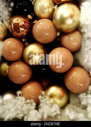 Palle di Natale. Christmastime, felice anno nuovo concetto. Decorazioni natalizie dorate su sfondo beige. Foto Stock