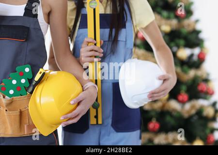 Team di costruzione con strumenti sullo sfondo del primo piano dell'albero di Capodanno Foto Stock